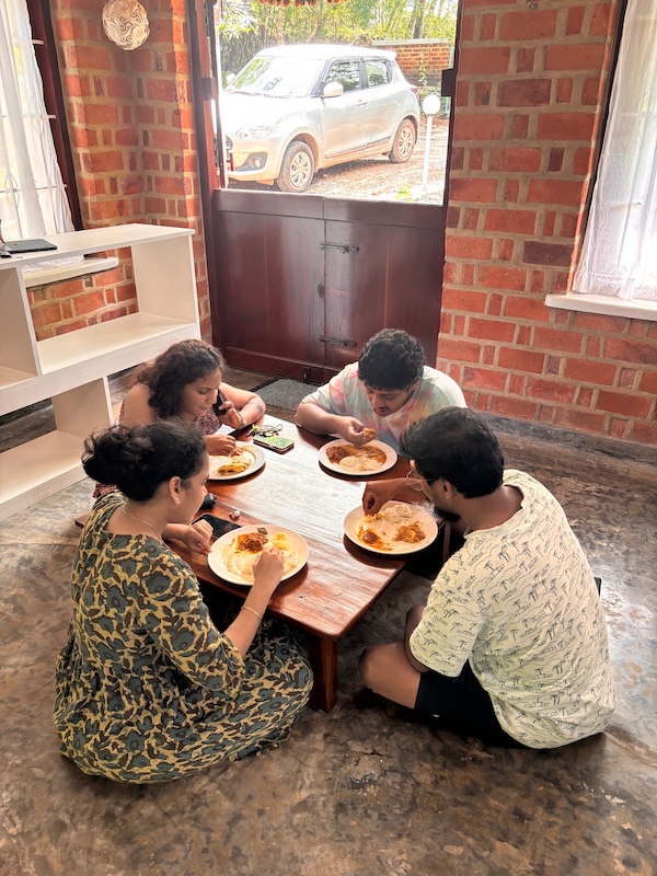 Guests enjoying a home-style Kerala meal together